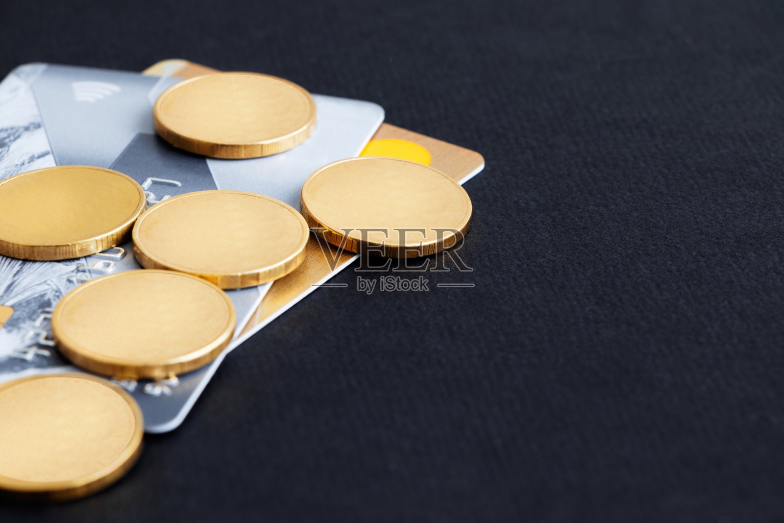 黑色背景上的信用卡和硬币。有选择性的重点。副本的空间。照片摄影图片