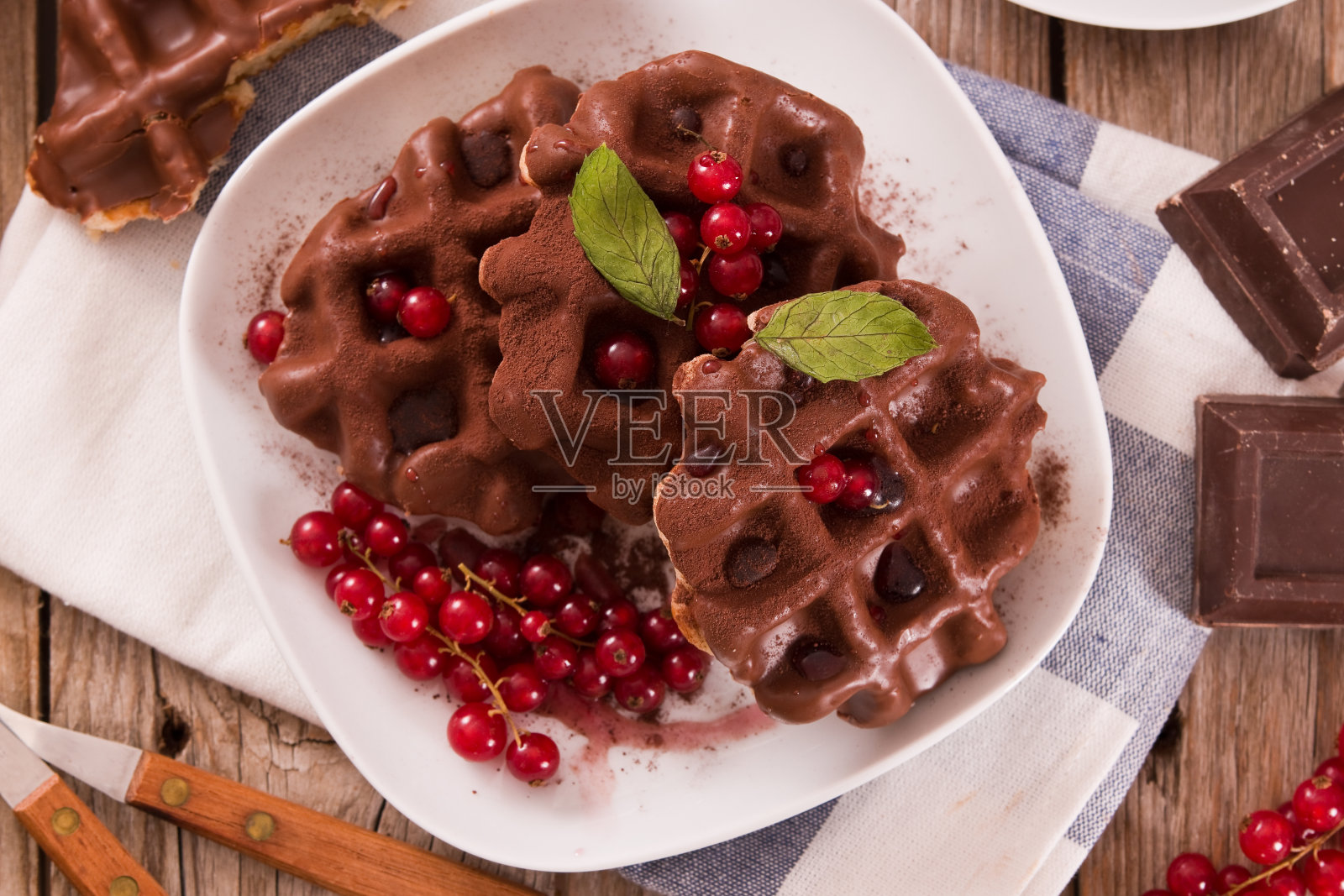 巧克力华夫饼，红醋栗和榛子。照片摄影图片
