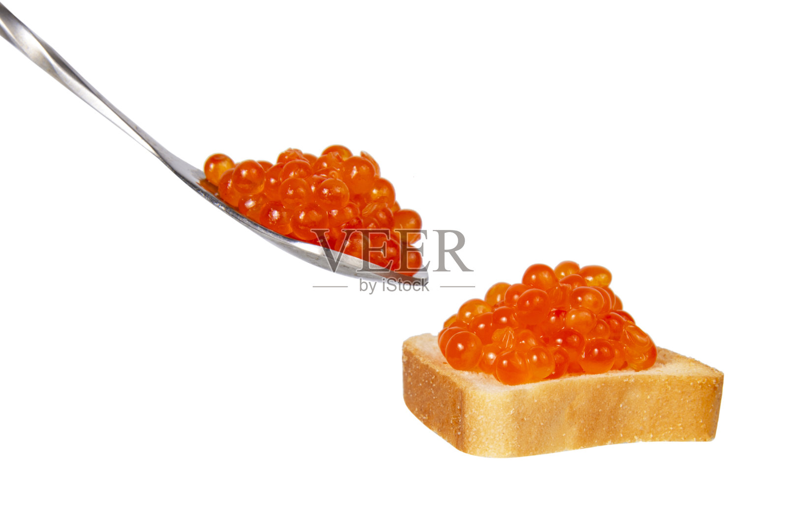 银色汤匙中的红色鱼子酱在白色的背景中分离照片摄影图片
