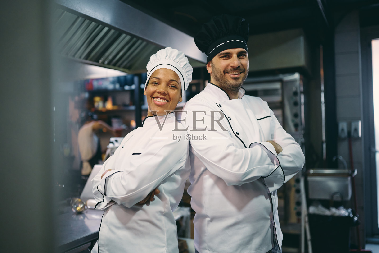 肖像快乐自信的专业厨师在餐厅厨房。照片摄影图片