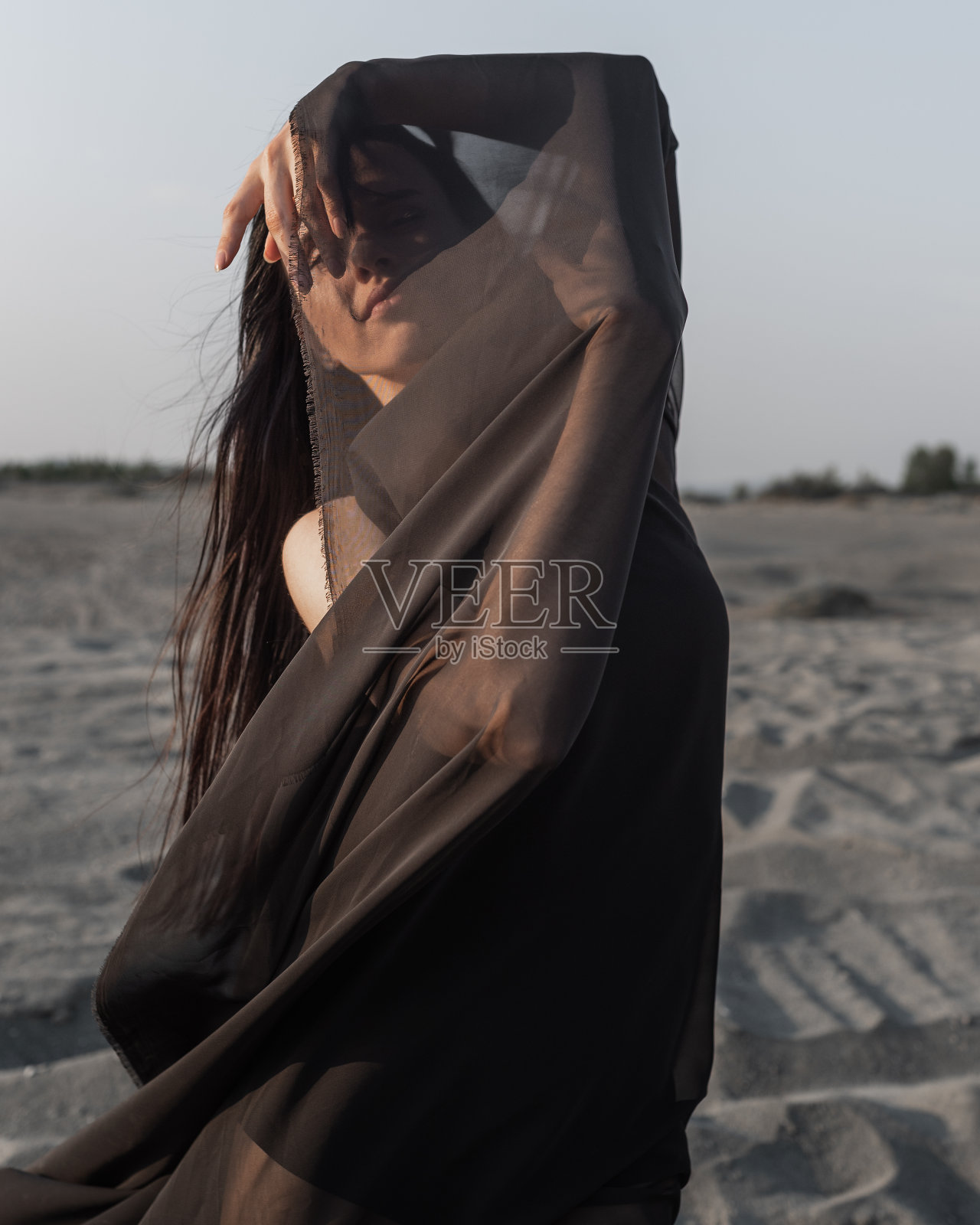 女孩的肖像覆盖了她的脸的一部分与黑色的布织物照片摄影图片