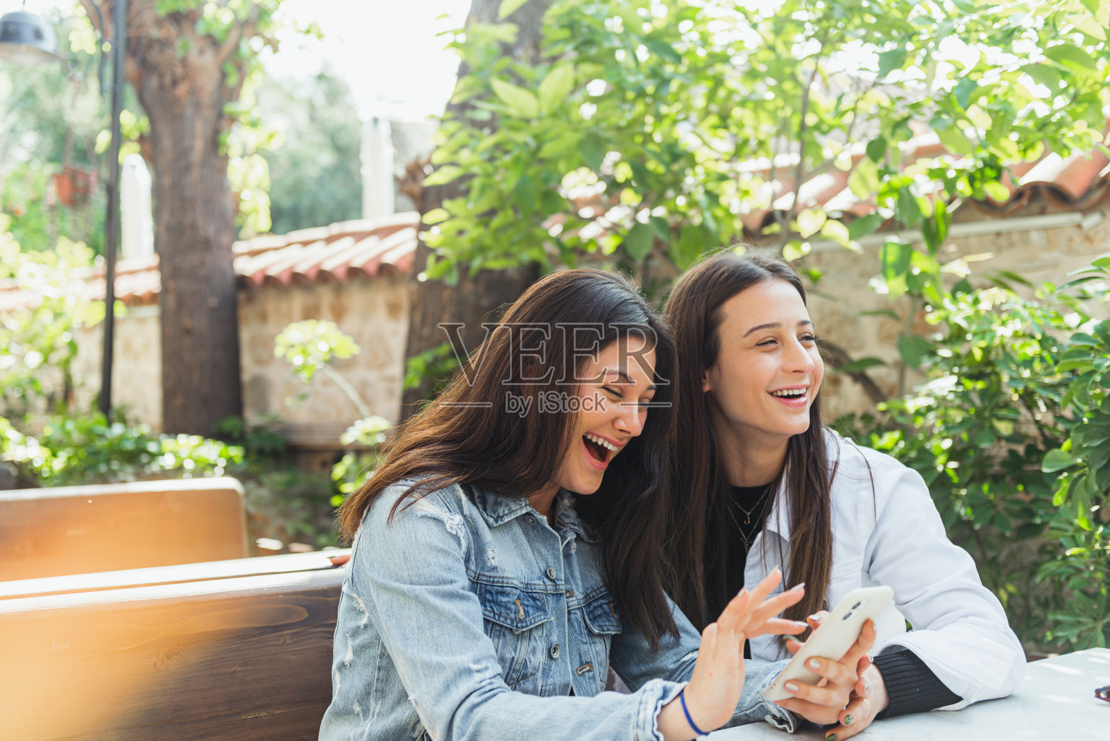 两个快活的年轻女人在咖啡馆里聊天照片摄影图片