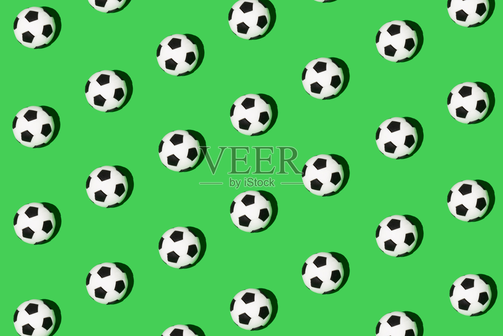 无缝图案做成的足球，足球隔离在绿色背景上。等距视图。体育的概念。照片摄影图片