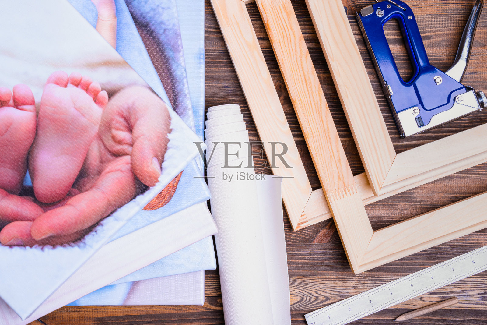 印刷在帆布上的照片，帆布拉伸在木制担架上。帆布拉伸工具，订书机，尺子和木框照片摄影图片