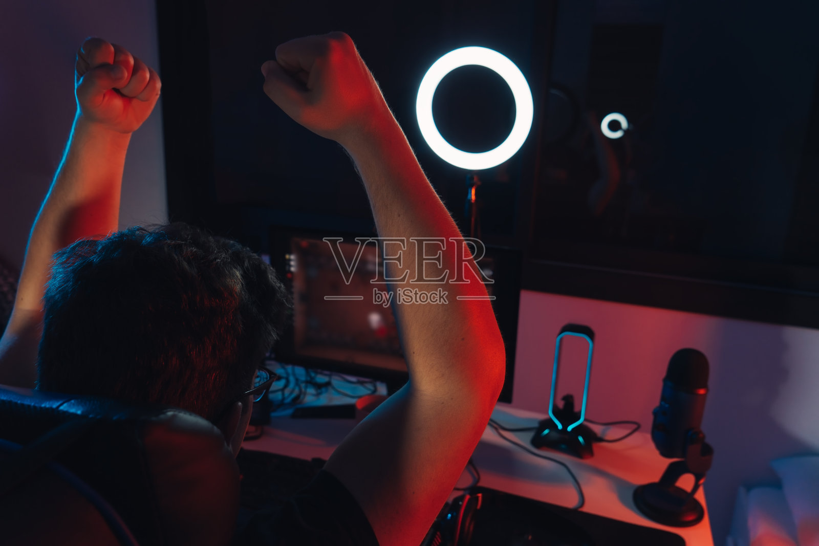 年轻人在直播专业网络游戏，庆祝胜利。视频游戏的概念。照片摄影图片
