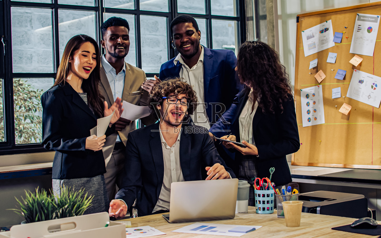 多元、多种族的精明商人穿着正装，使用电脑，通过电话会议讨论，在室内现代办公室为公司营销计划集思广益。照片摄影图片