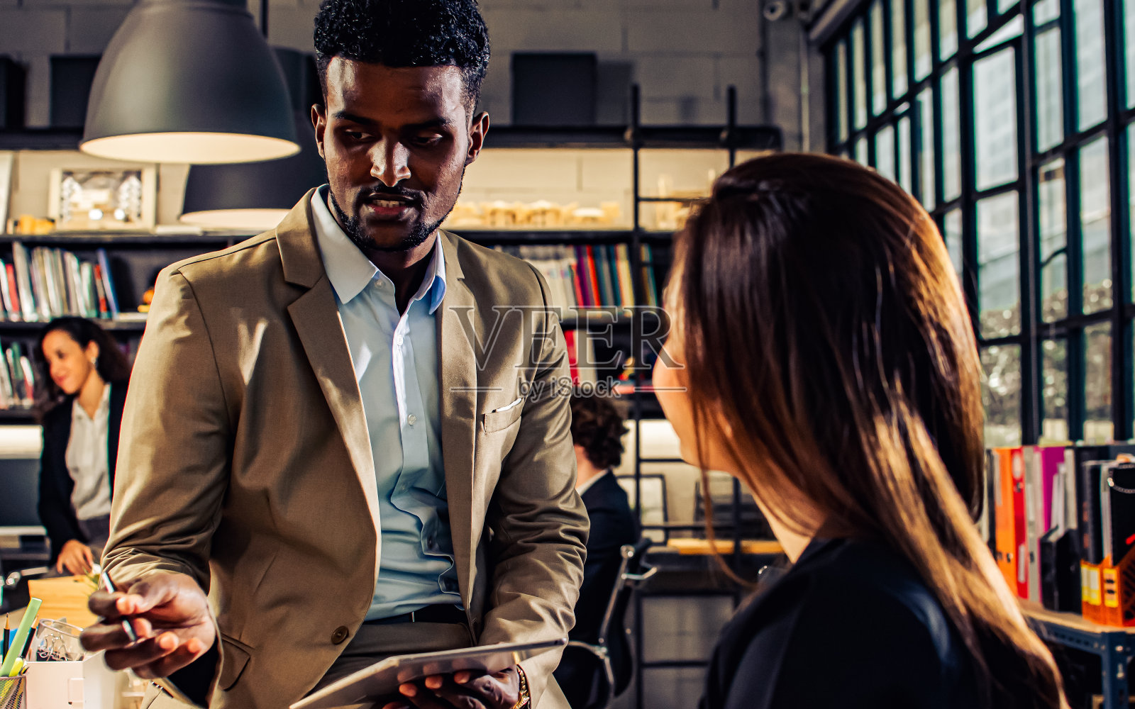 英俊非洲商人穿正装在办公室讨论项目照片摄影图片