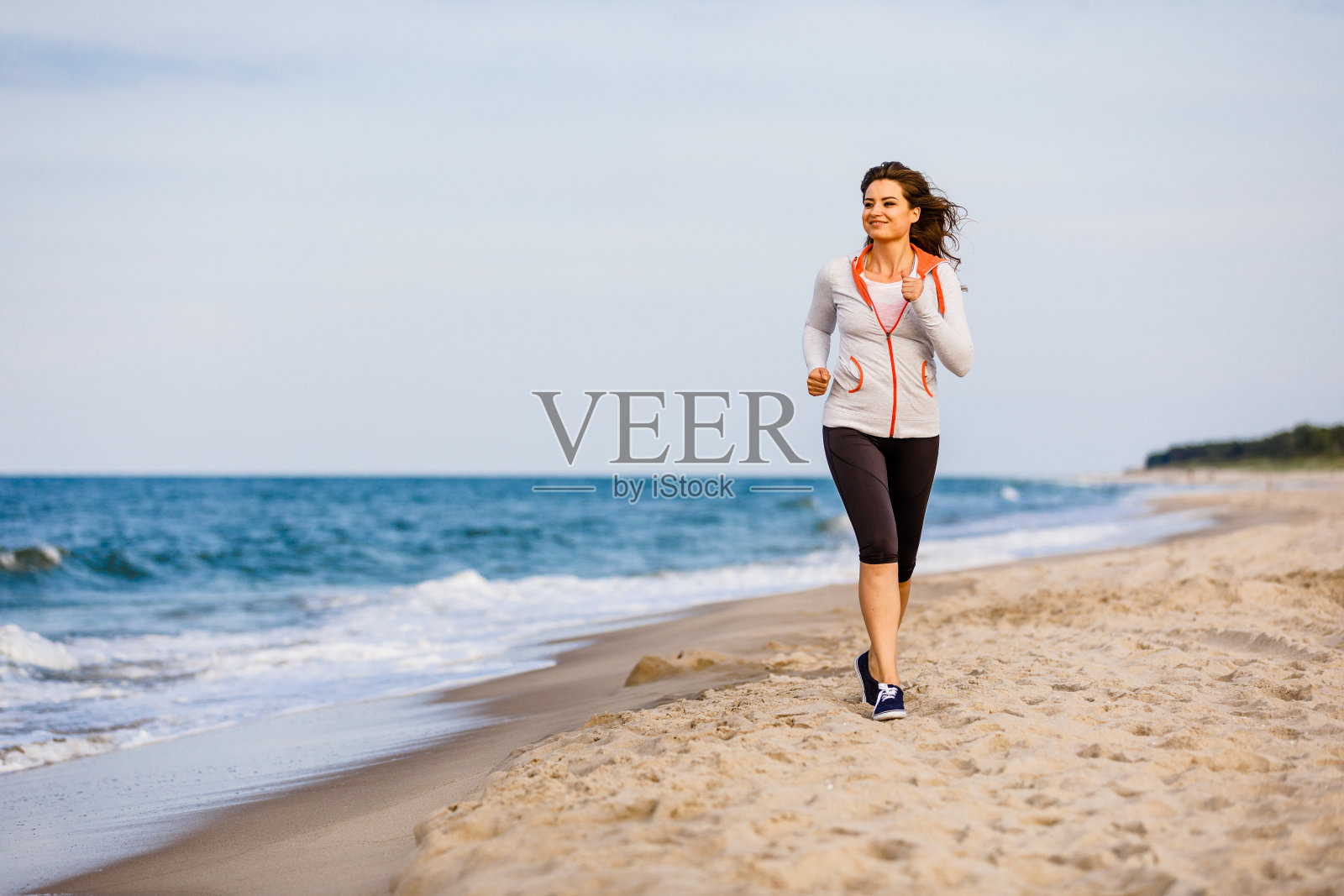 年轻女子在沙滩上奔跑照片摄影图片