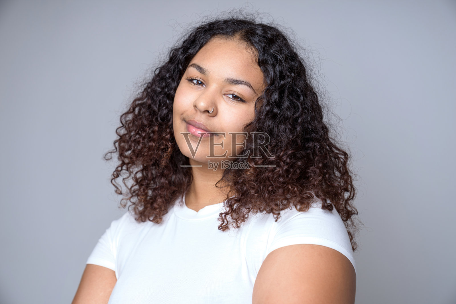 工作室肖像的美丽黑发年轻深色皮肤的女人在灰色的背景照片摄影图片