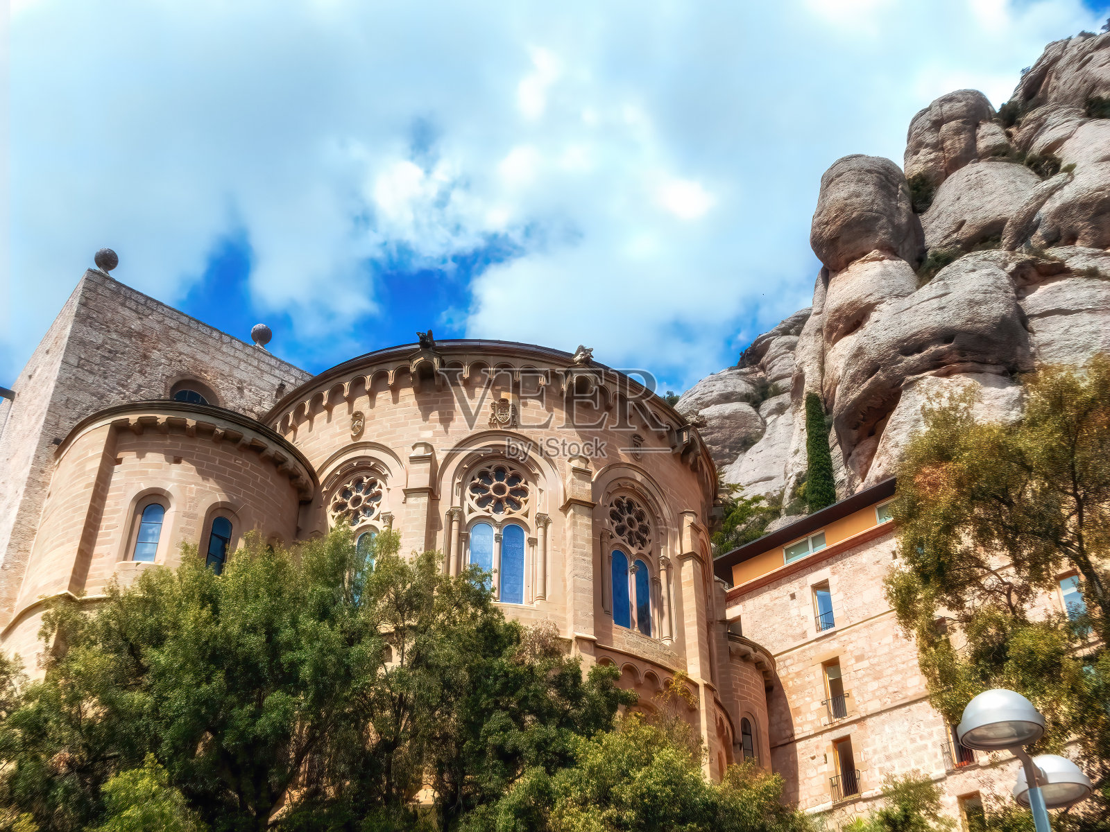 蒙特塞拉特的天主教修道院，背景是圆形的岩石。蓝色的天空。西班牙加泰罗尼亚。照片摄影图片