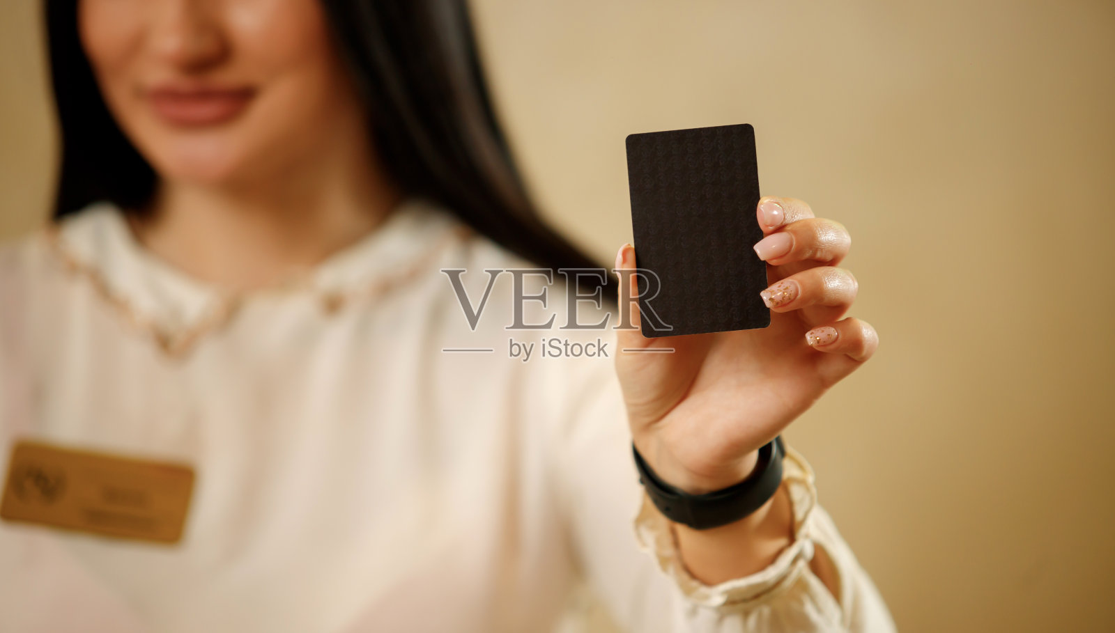 前台女孩手里拿着探照卡。关闭了。前台的女主人拿着公司或酒店的名片。放置logo的地方照片摄影图片