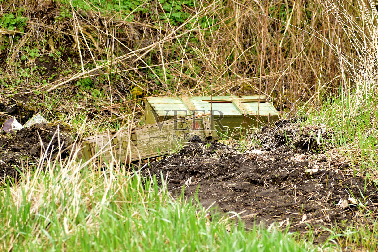 放置炮弹的木制门框被遗忘在草地上。照片摄影图片