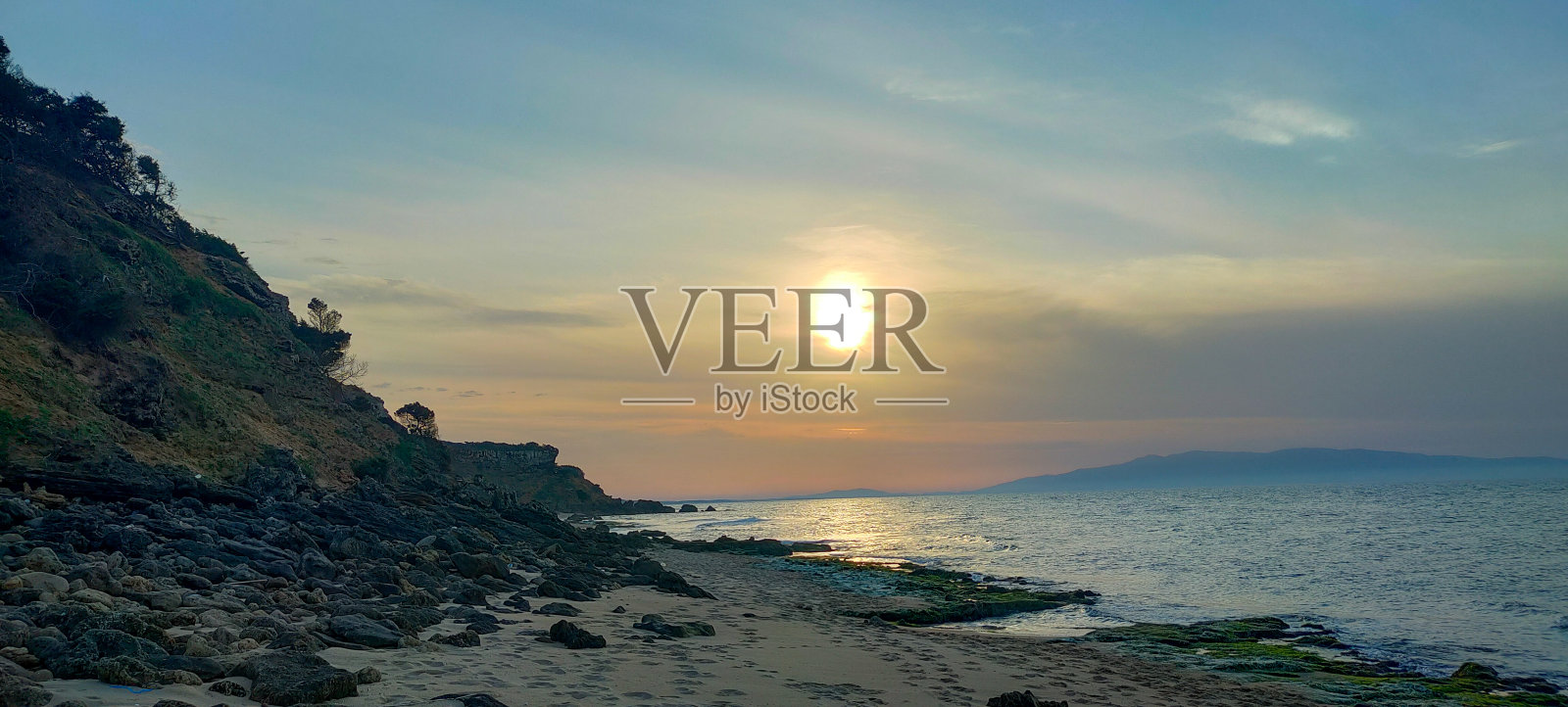 日落时分的岩石海滩照片摄影图片