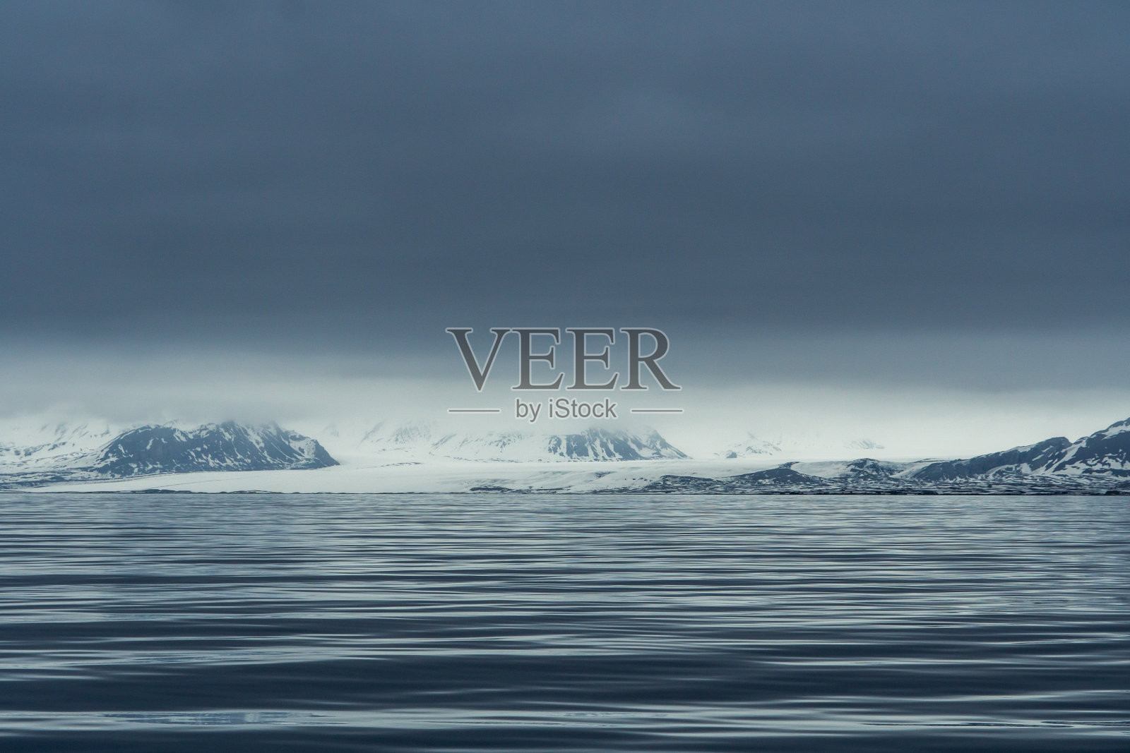 在挪威斯瓦尔巴群岛的山脉、雪和大海的蓝色时刻的全景。照片摄影图片