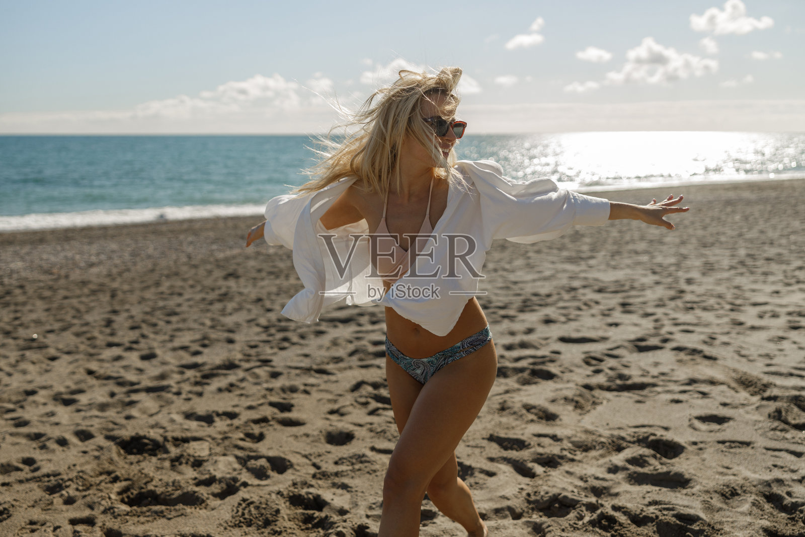 穿着泳装的活跃女性在暑假期间的海滩上玩耍照片摄影图片