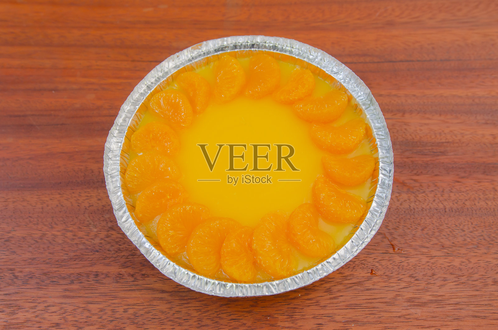 木桌上装饰着新鲜橙子的橘子蛋糕。照片摄影图片