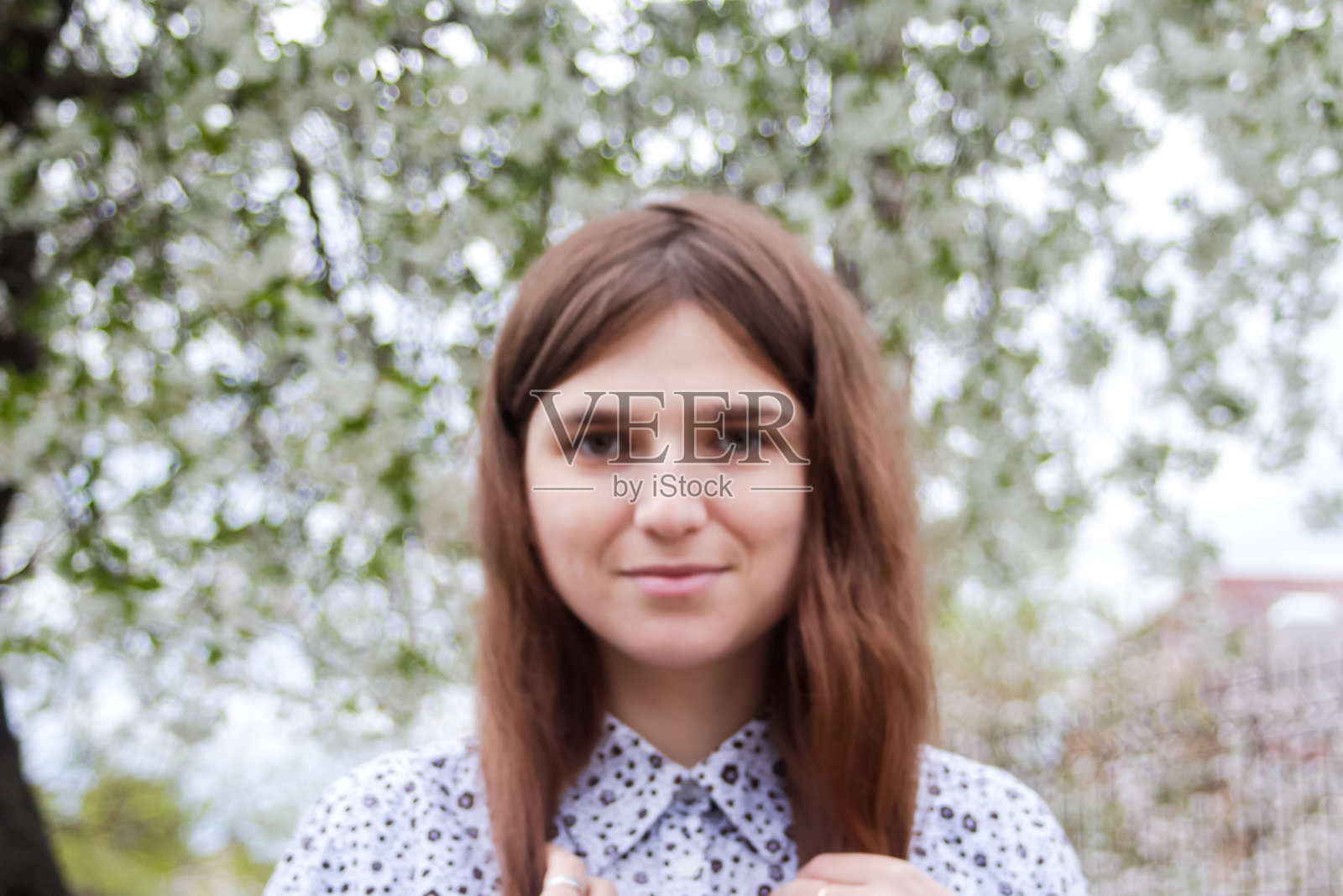 散焦的深色长发白种白种女人女孩户外生活方式肖像在春天浪漫的芳香自然公园周围开花的树。浪漫的肖像。梦想,幸福。的焦点照片摄影图片