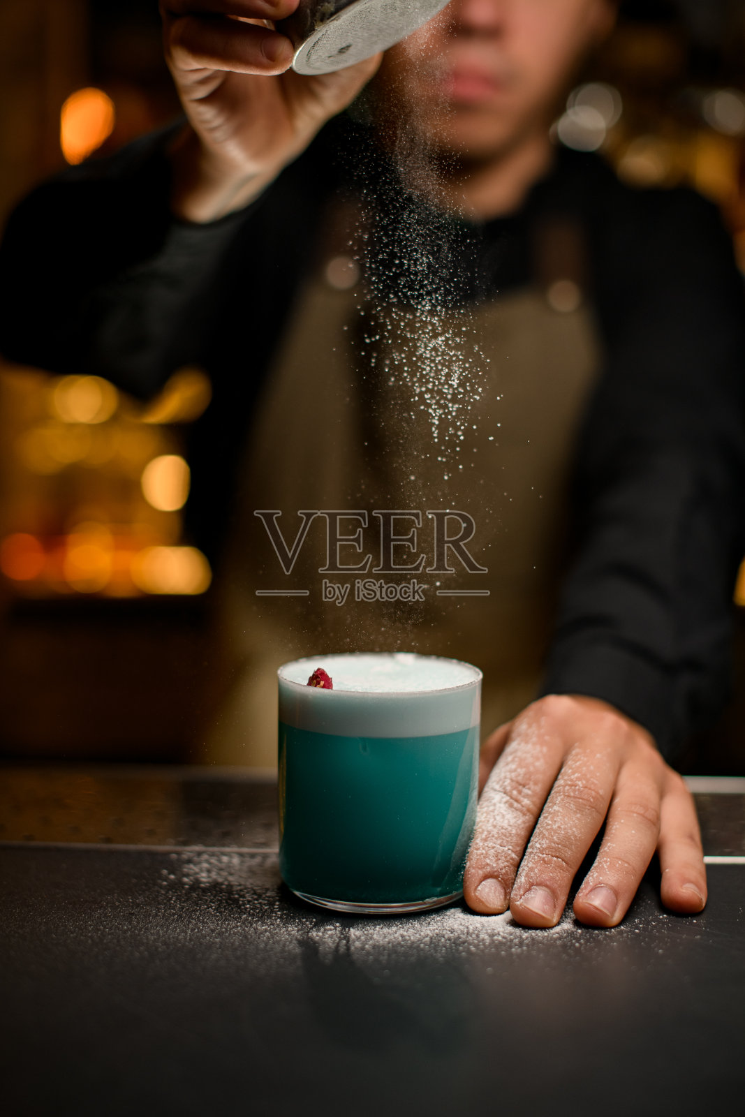 美丽的景色玻璃与蓝色泡沫饮料站在酒吧和糖粉倒在它。照片摄影图片