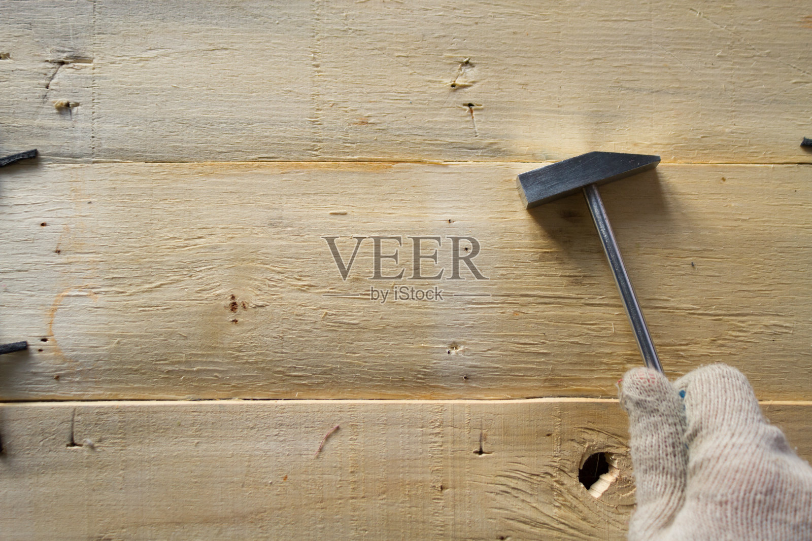 手拿锤子放在木制背景上照片摄影图片