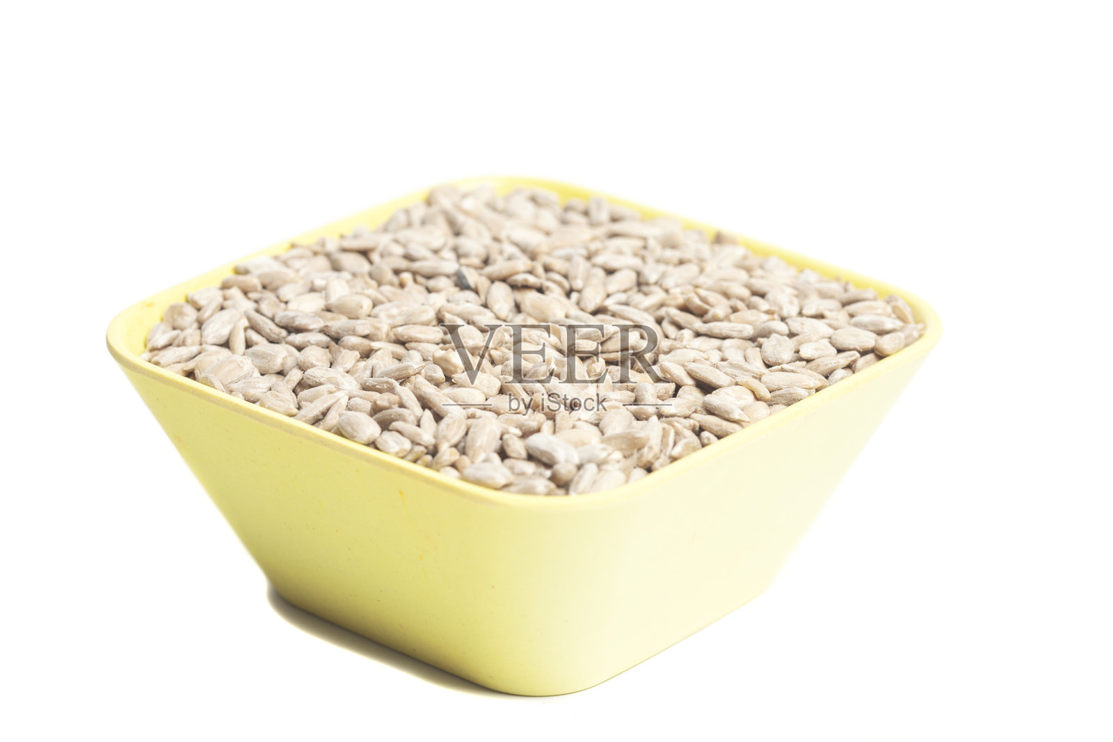 向日葵去皮的种子在杯子中隔离在白色的背景上照片摄影图片