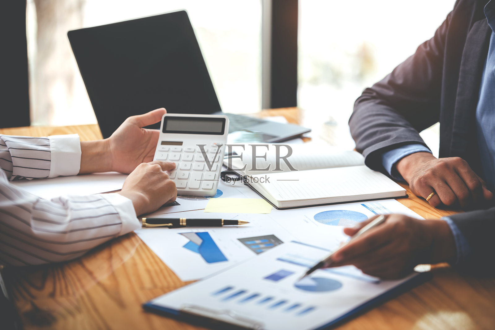 团队合作，将商业分析价格图表放在会议室的桌子上。照片摄影图片