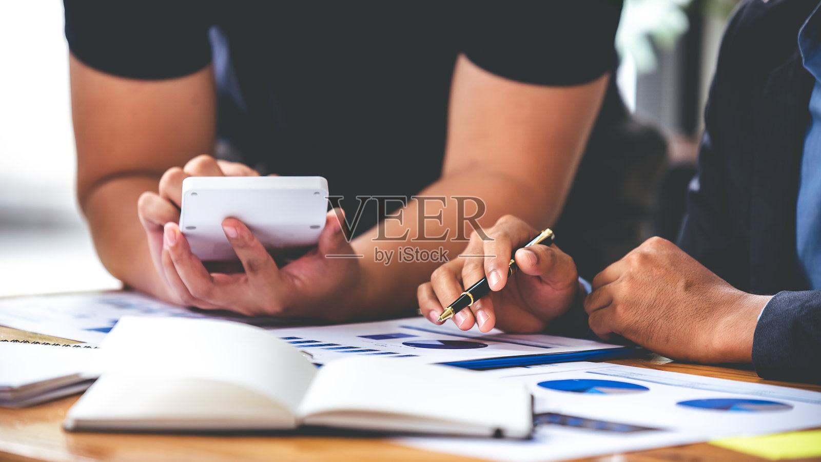 团队合作，将商业分析价格图表放在会议室的桌子上。照片摄影图片
