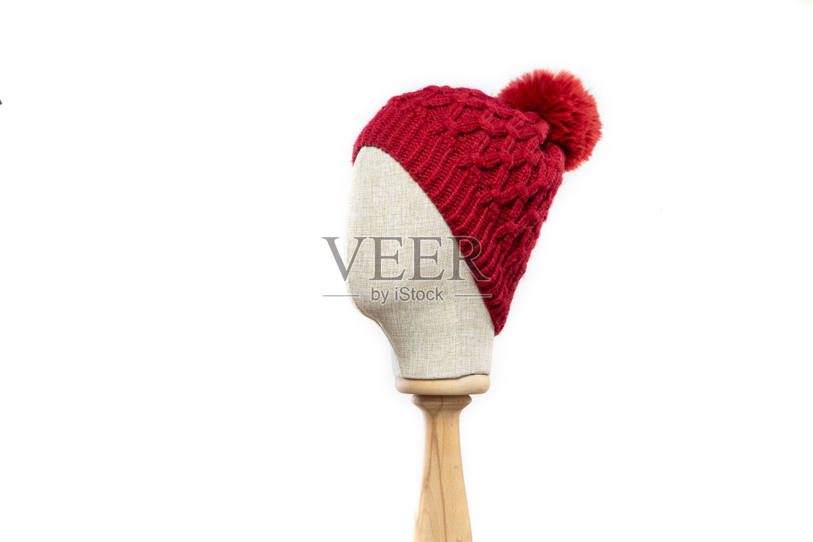 白色背景上印有人体模型头像的红色针织无檐帽照片摄影图片