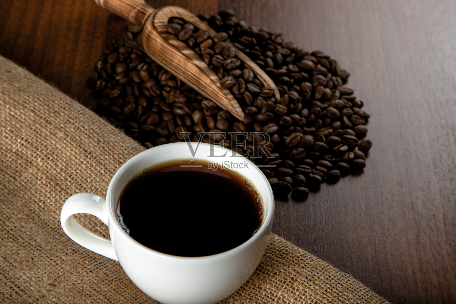一杯咖啡，咖啡豆放在木制背景上照片摄影图片