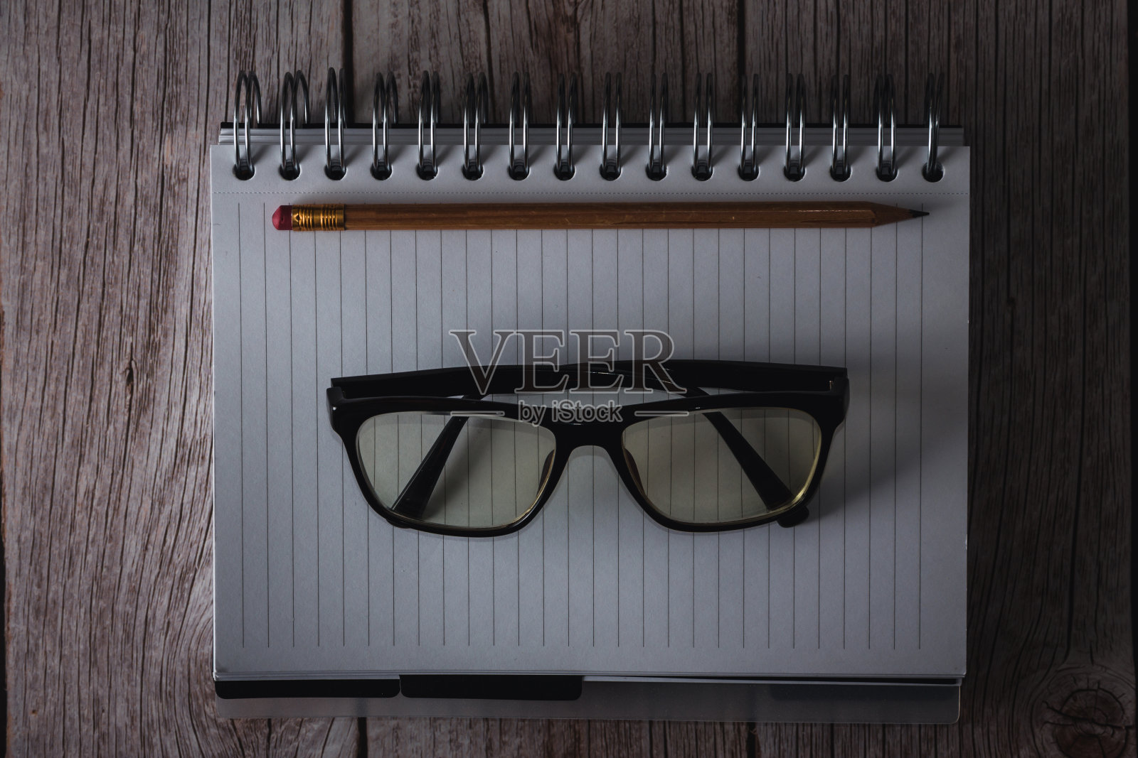 木质背景上的铅笔和眼镜笔记本照片摄影图片
