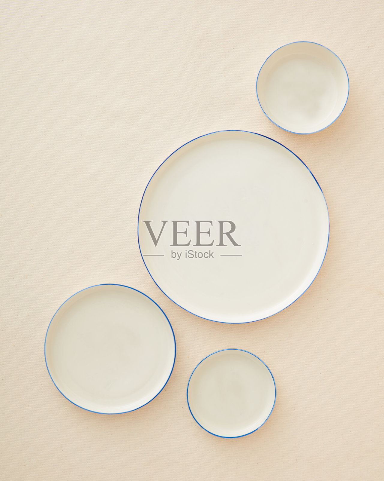 米色背景上的手工陶瓷板。照片摄影图片