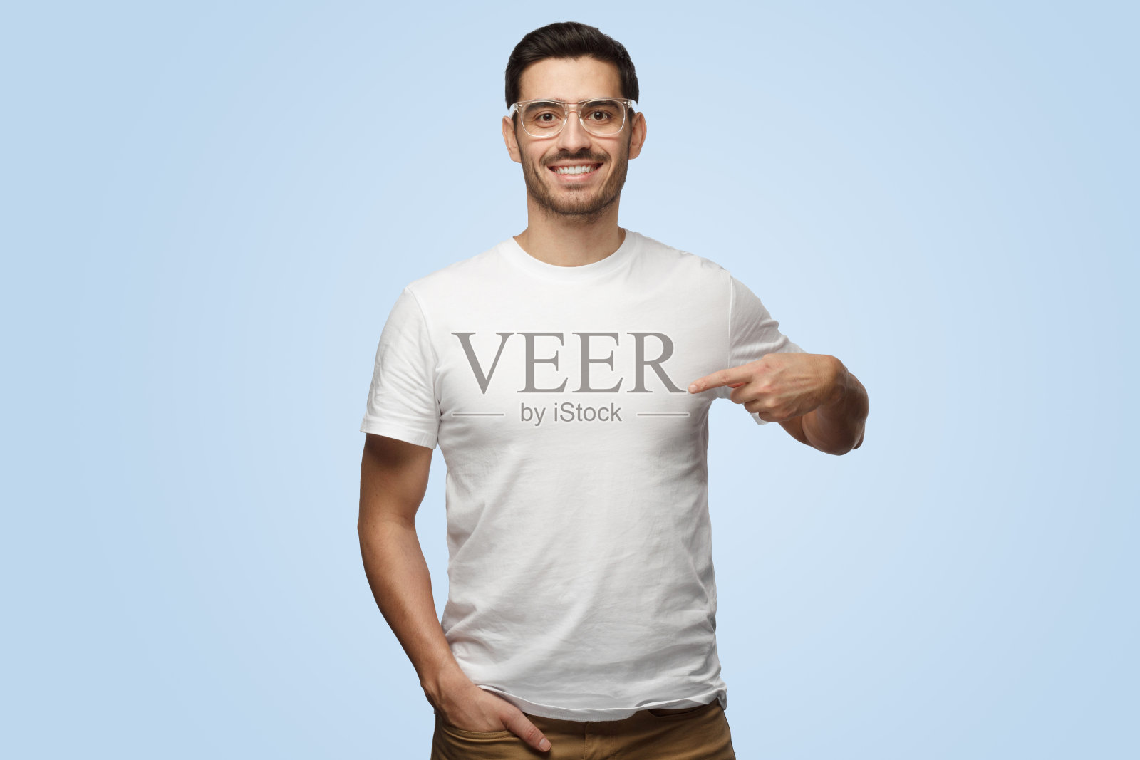 有魅力的欧洲男子用食指指着他的白t恤照片摄影图片