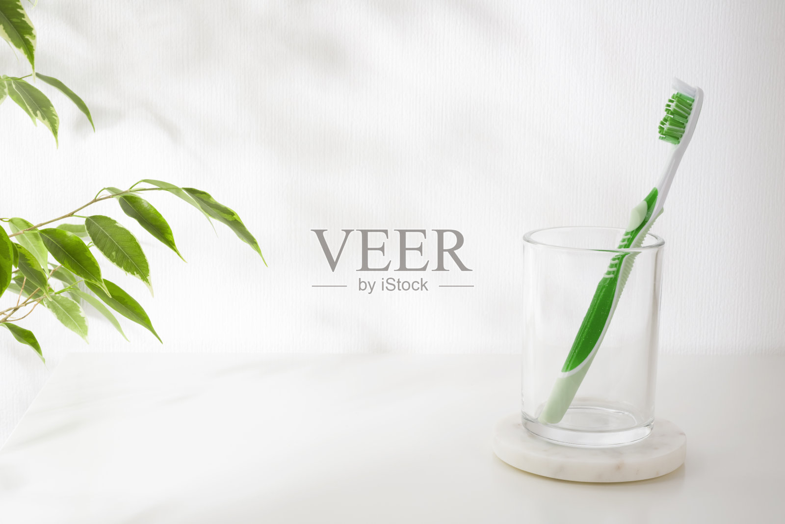 大理石支架上的玻璃支架，白色背景上有牙刷照片摄影图片