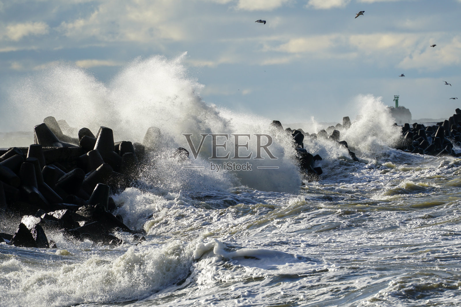 在冬季风暴中，海浪撞击防波堤照片摄影图片