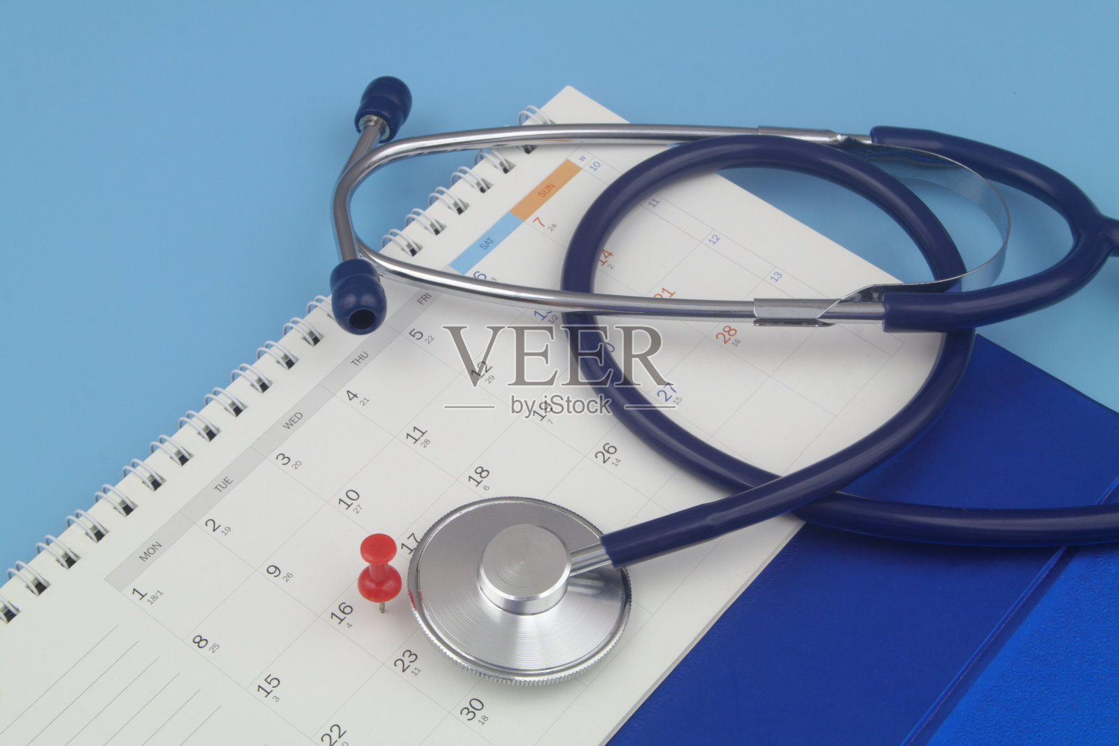 带有图钉的日历上的听诊器照片摄影图片