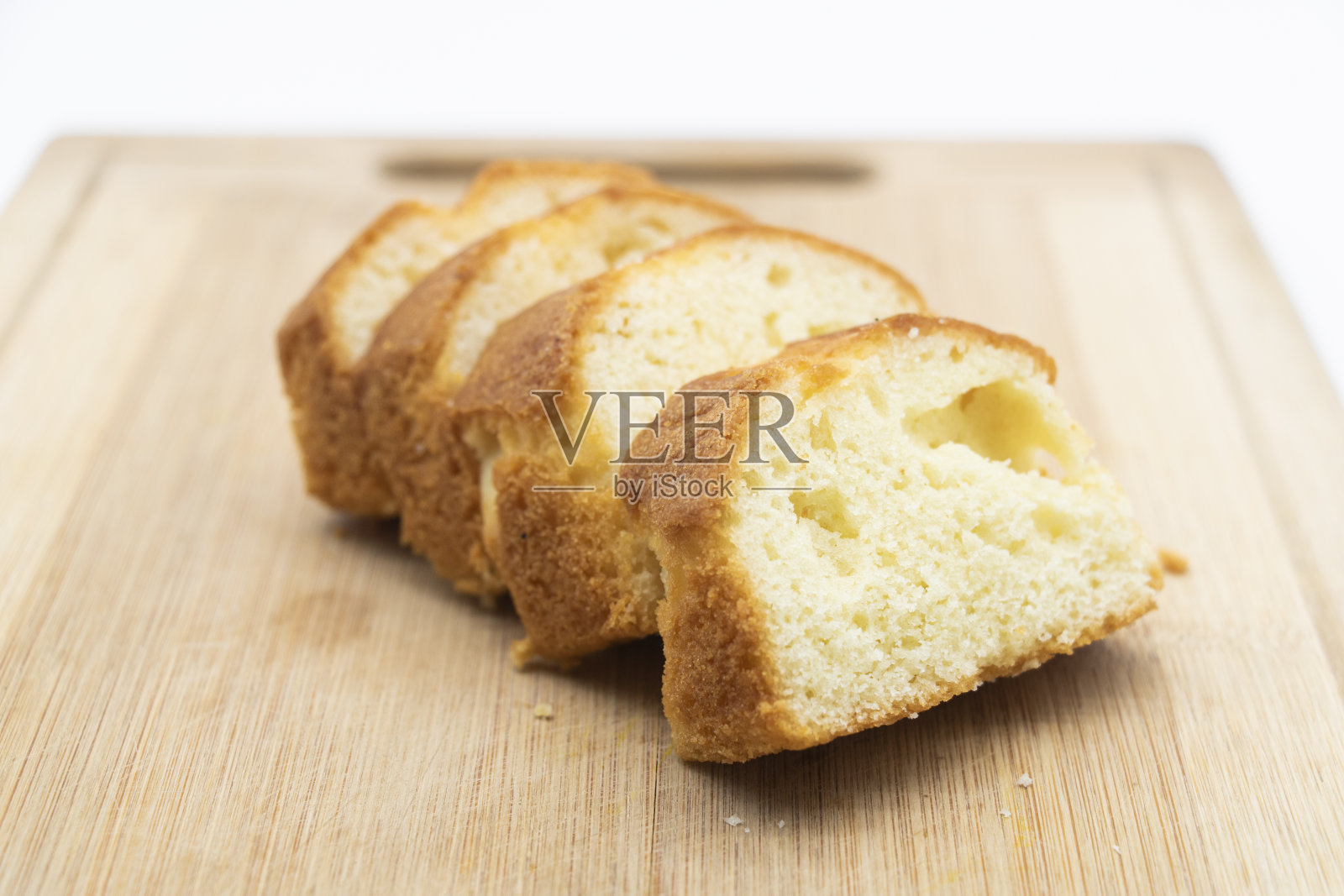 将蛋糕放在砧板上，孤立在白色背景上照片摄影图片