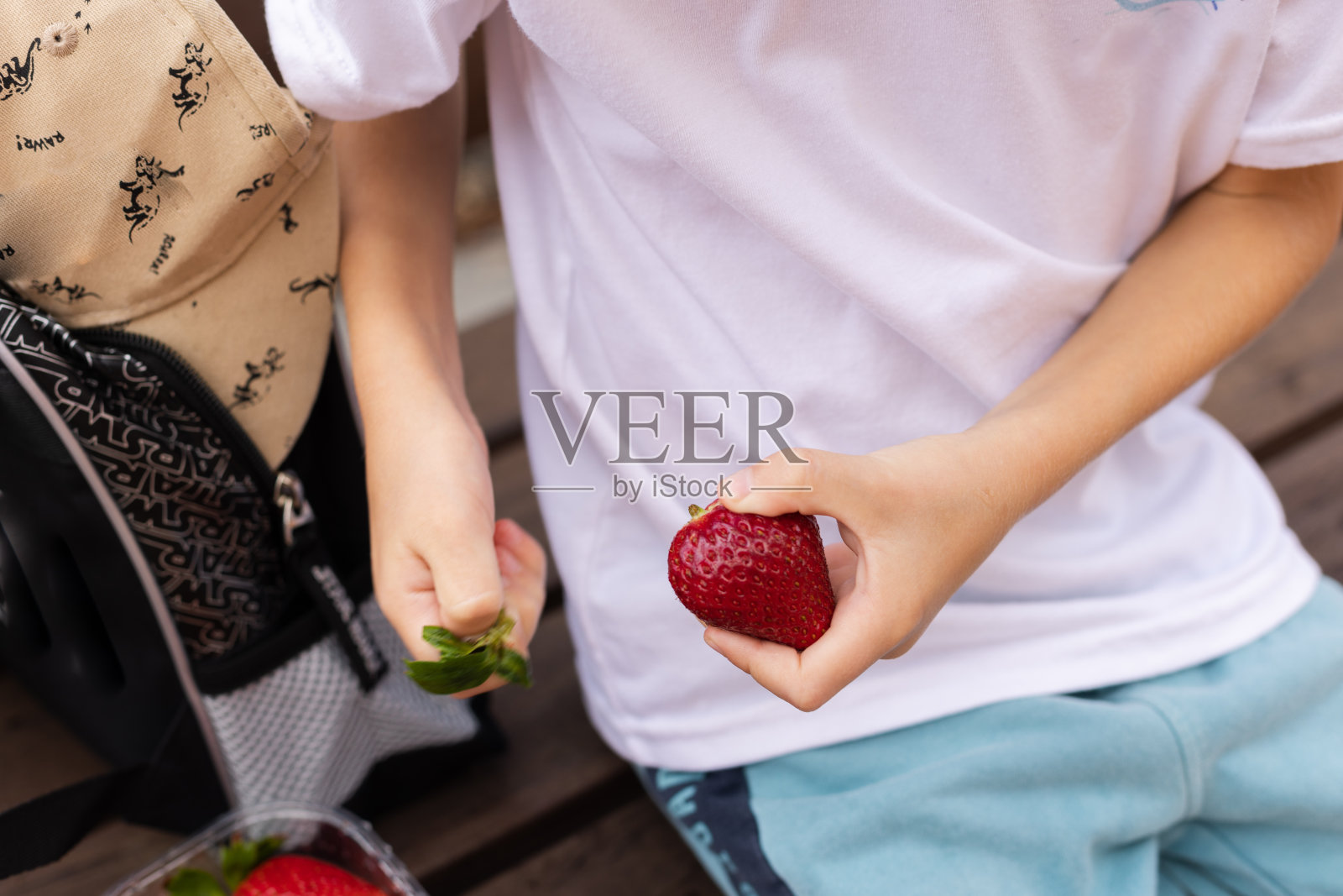 儿童手中拿着大颗成熟的草莓照片摄影图片