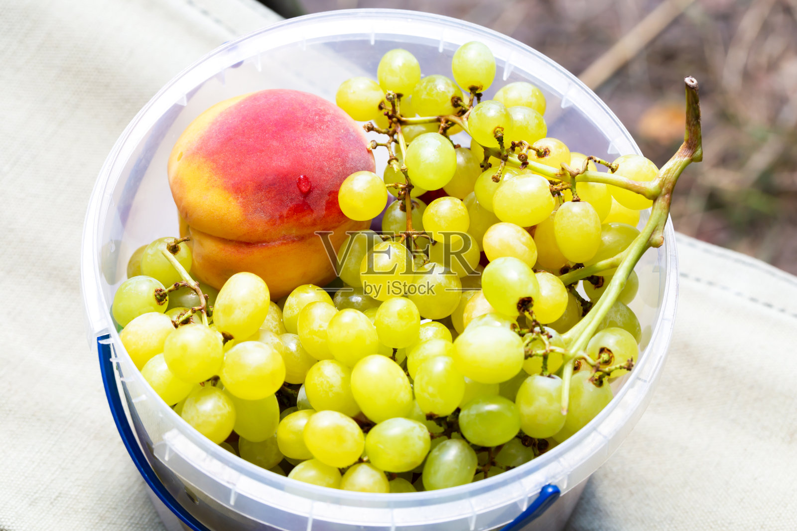 塑料桶里装着葡萄和桃子照片摄影图片