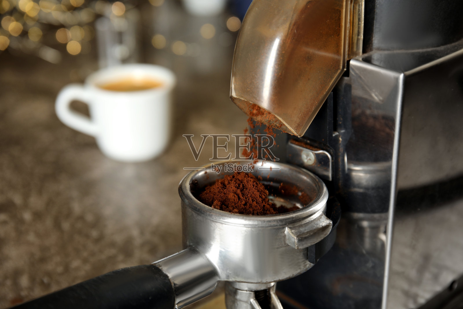 将咖啡粉从研磨机倒入滤器，特写照片摄影图片