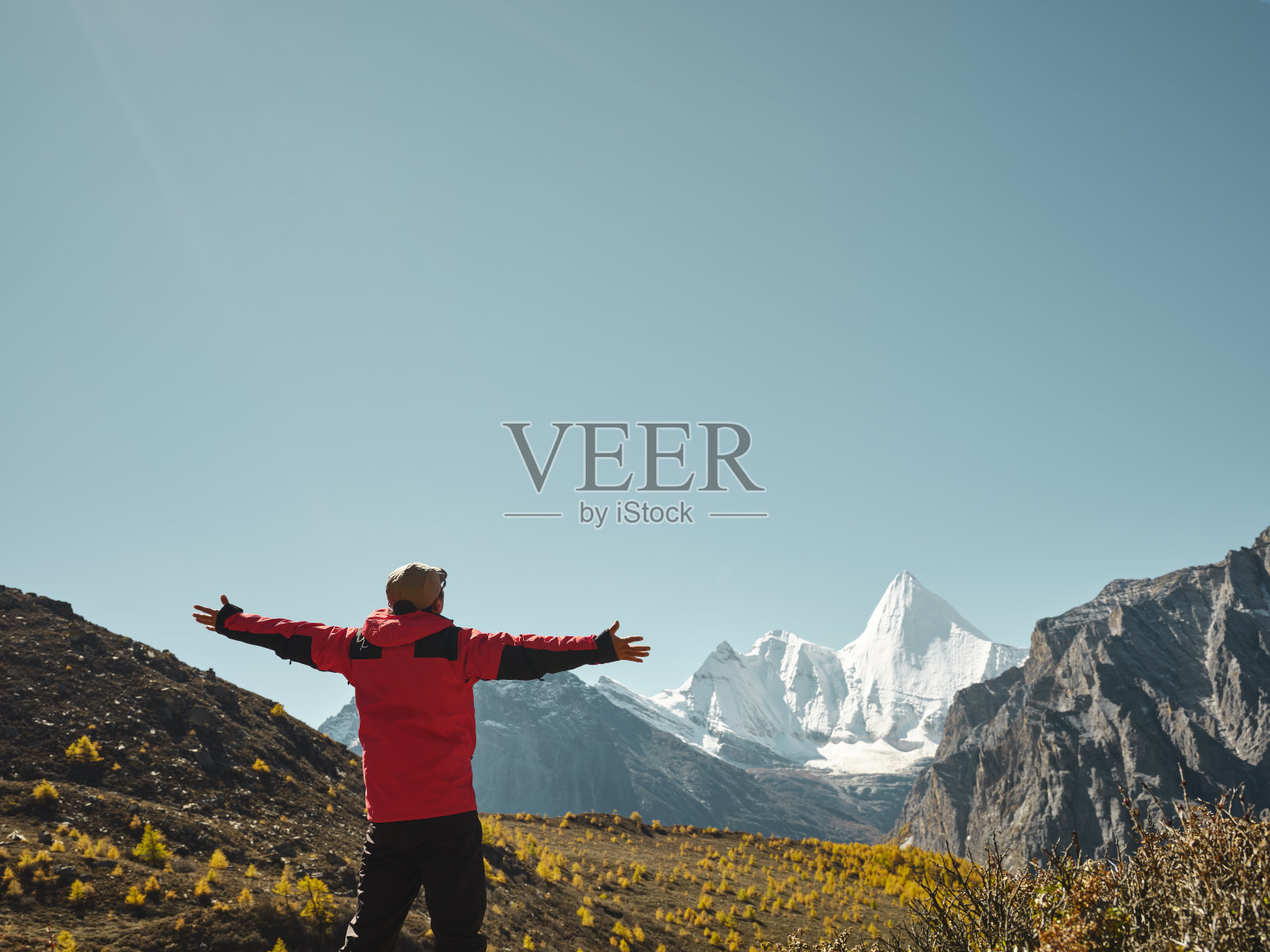 一个亚洲人在看中国亚丁的扬迈勇山(藏语叫jampayyang)照片摄影图片