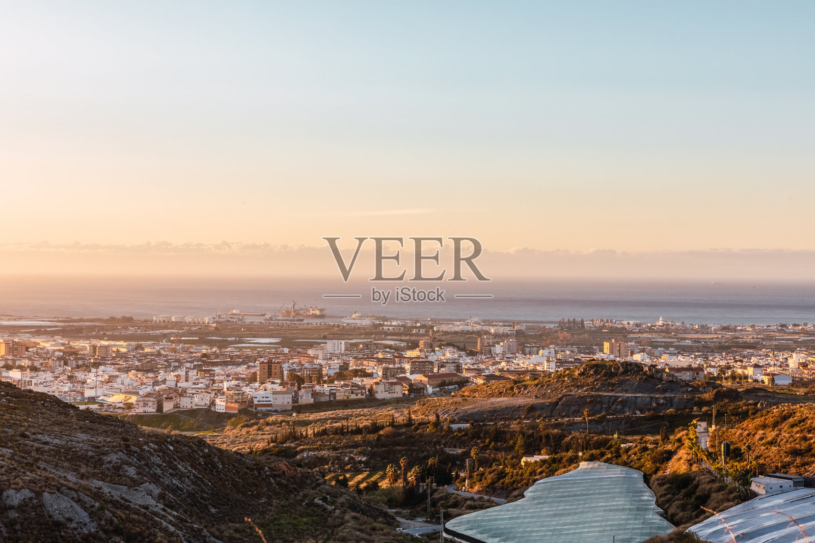 西班牙安达卢西亚，格拉纳达海岸的温室里的日落，背景是莫特里尔照片摄影图片