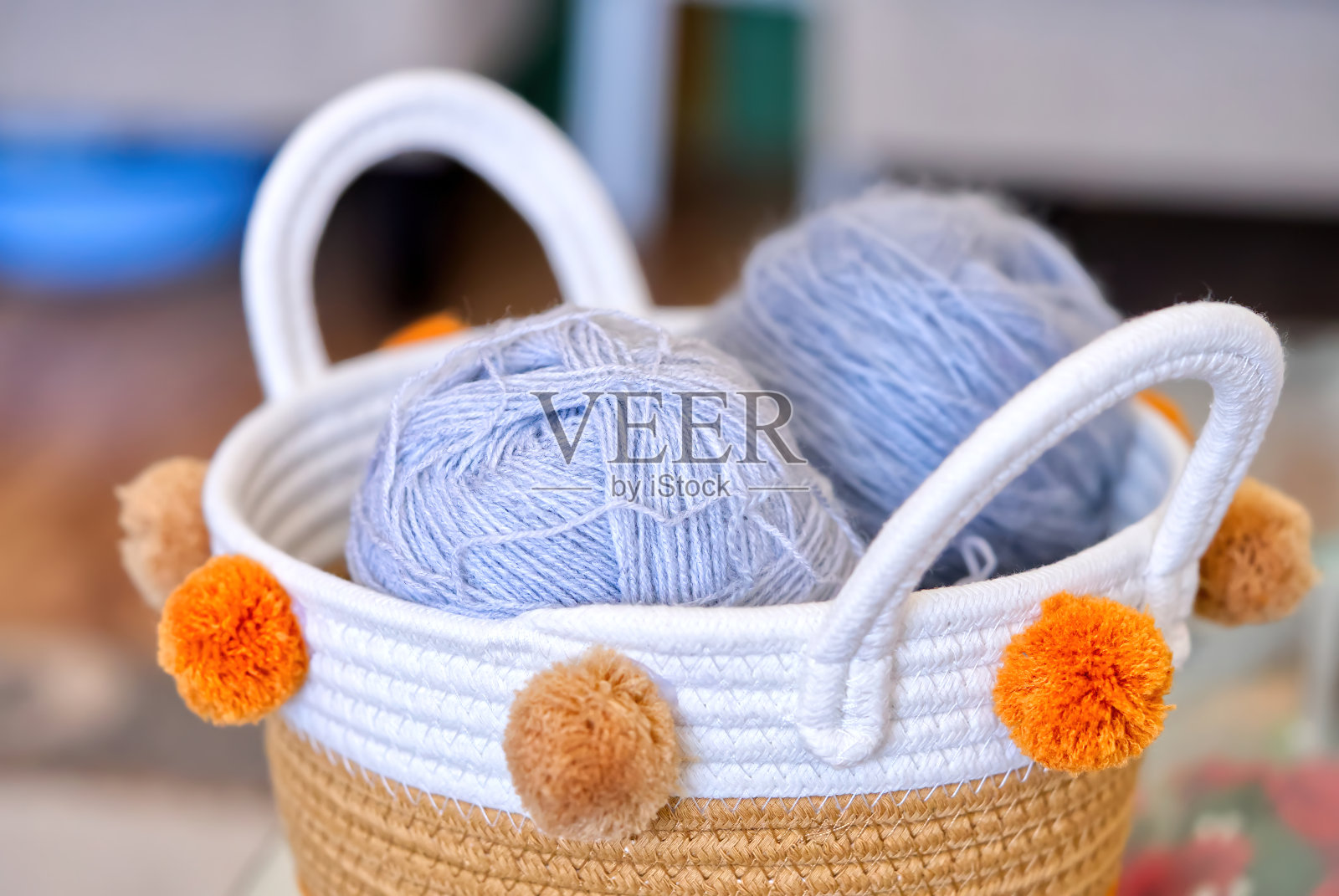 顶视图的一个柳条篮子球羊毛纱线手工编织和一套钩子和编织针在一个旧的木桌。照片摄影图片