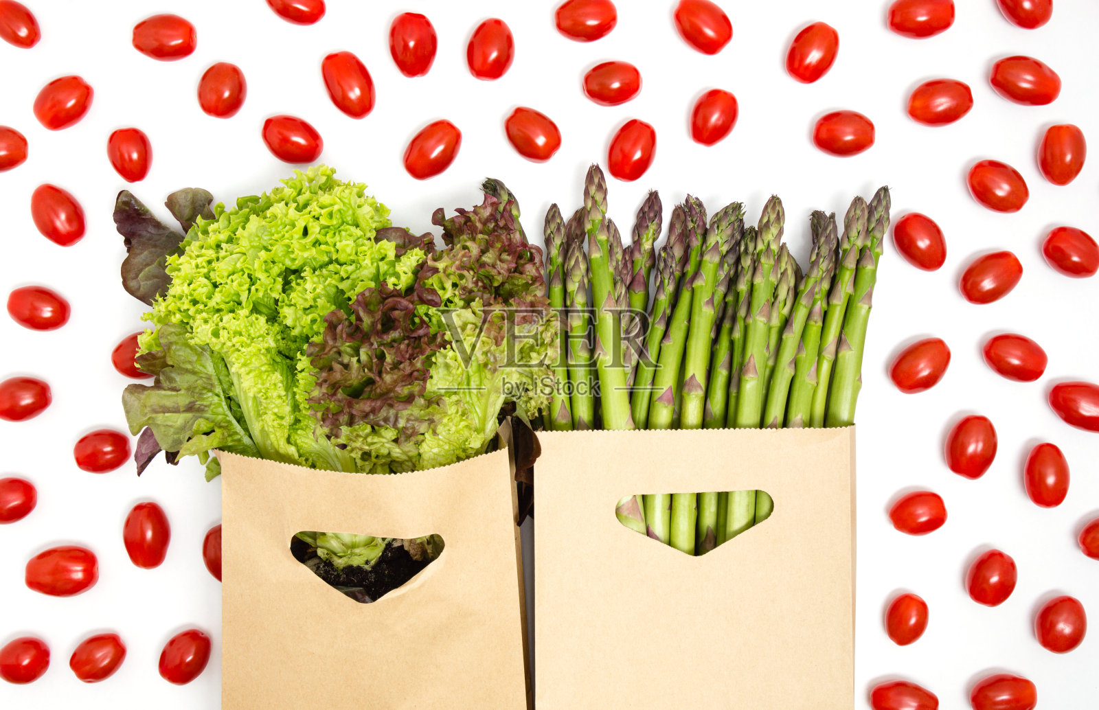 绿色和红色蔬菜-生菜，芦笋和圣女果孤立在白色背景。健康饮食，素食产品，杂货店购物，捐赠或食品配送的概念。前视图。照片摄影图片