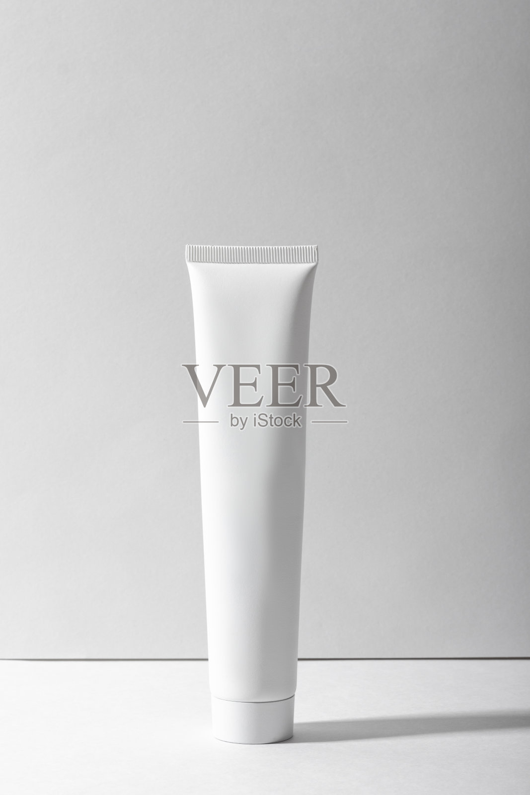 白色化妆管在白色背景与阴影。滋润保湿面霜、护手霜或乳液。女性化妆用护肤品管。照片摄影图片