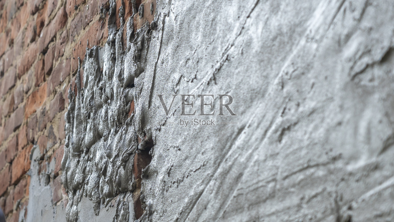 房屋装修墙面抹灰。用灰泥在墙上抹平灰泥。腻子砖墙背景照片摄影图片