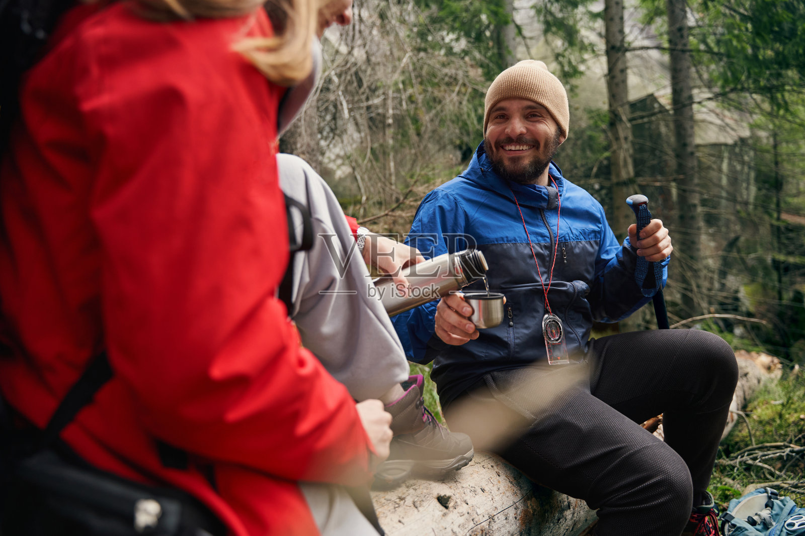 感激的男人盯着给他的保温杯斟酒的女游客照片摄影图片