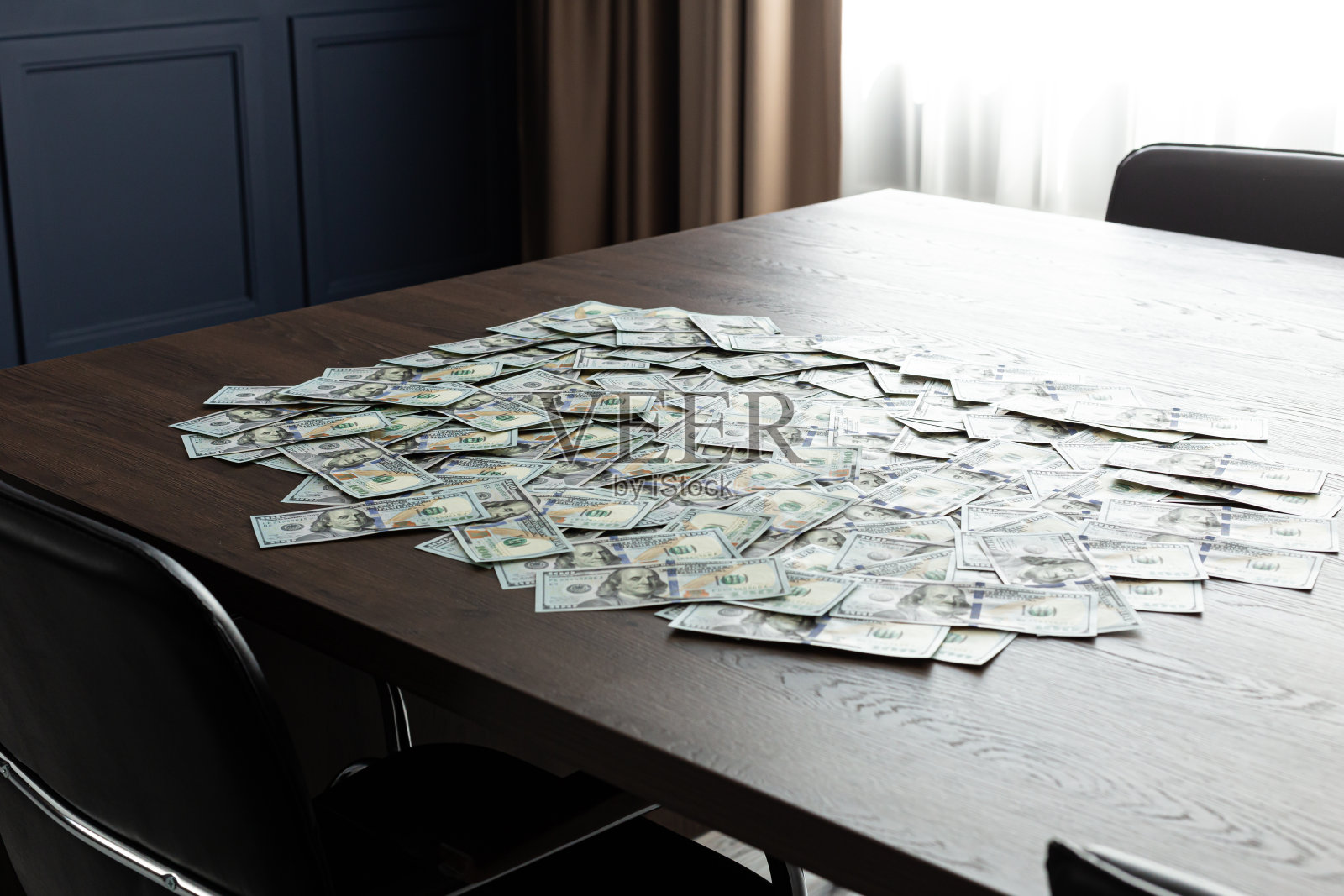 100美元的现金账单在办公室的桌子上。一大笔钱照片摄影图片