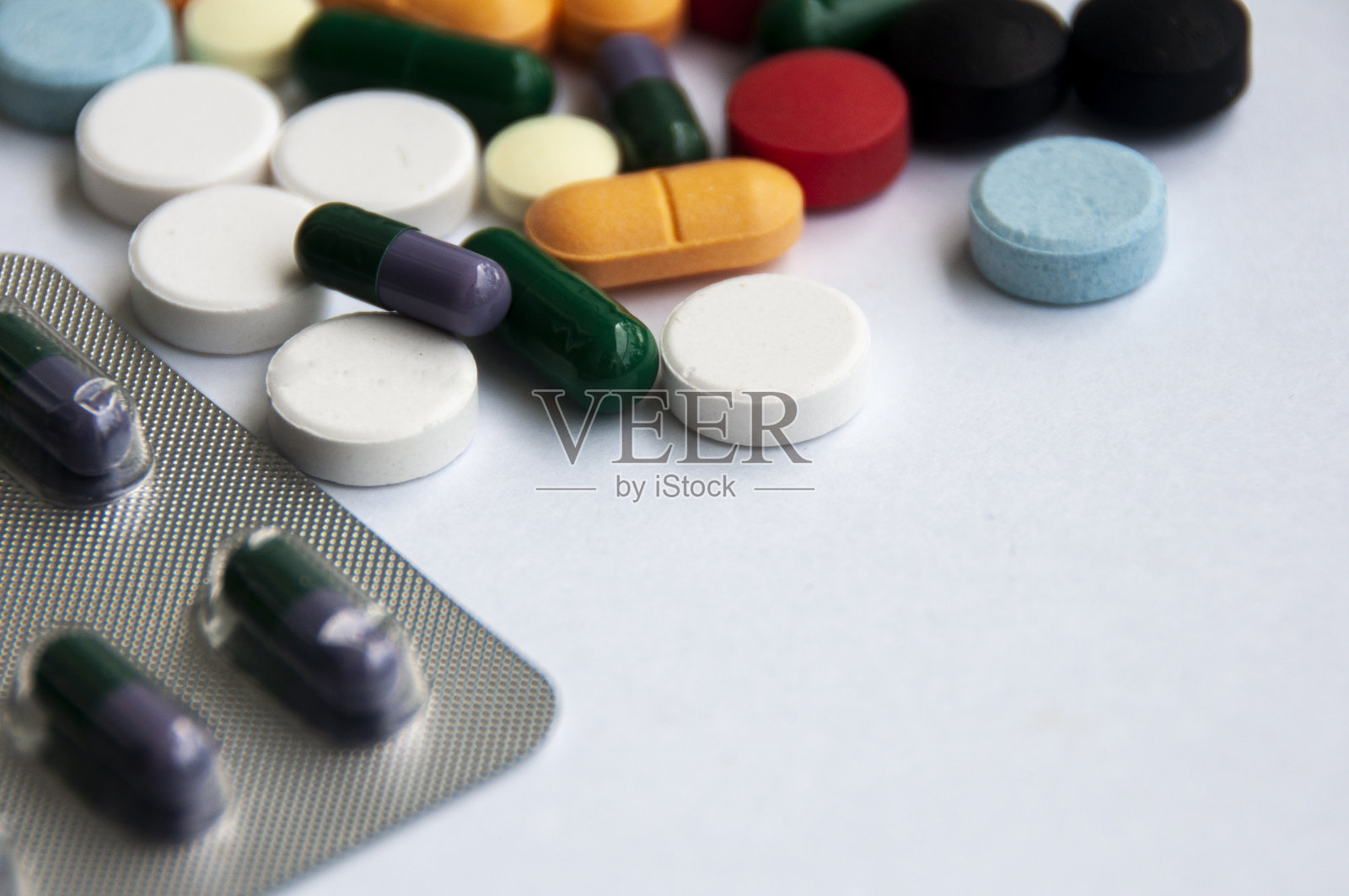 各种药物药丸，片剂和胶囊模糊的背景上的白色背景。医疗保健和医学的概念。照片摄影图片