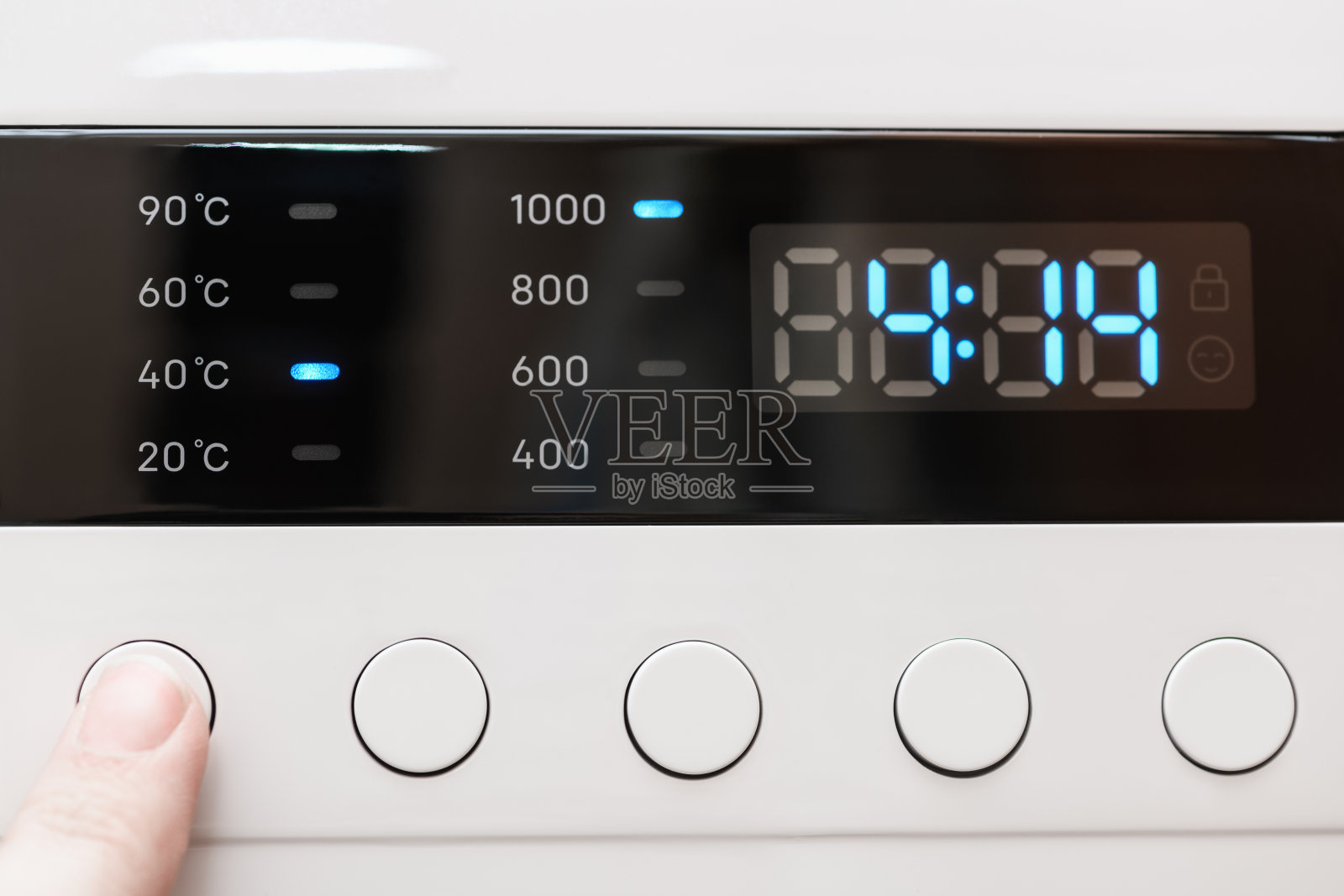 洗衣机显示关闭，洗涤过程中剩余时间4小时14分钟。手指选择清洗模式。抽象洗衣编程背景照片摄影图片