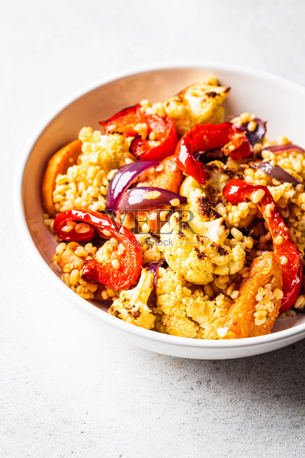 烤蔬菜沙拉，白碗碾碎干。素食食品的概念。照片摄影图片