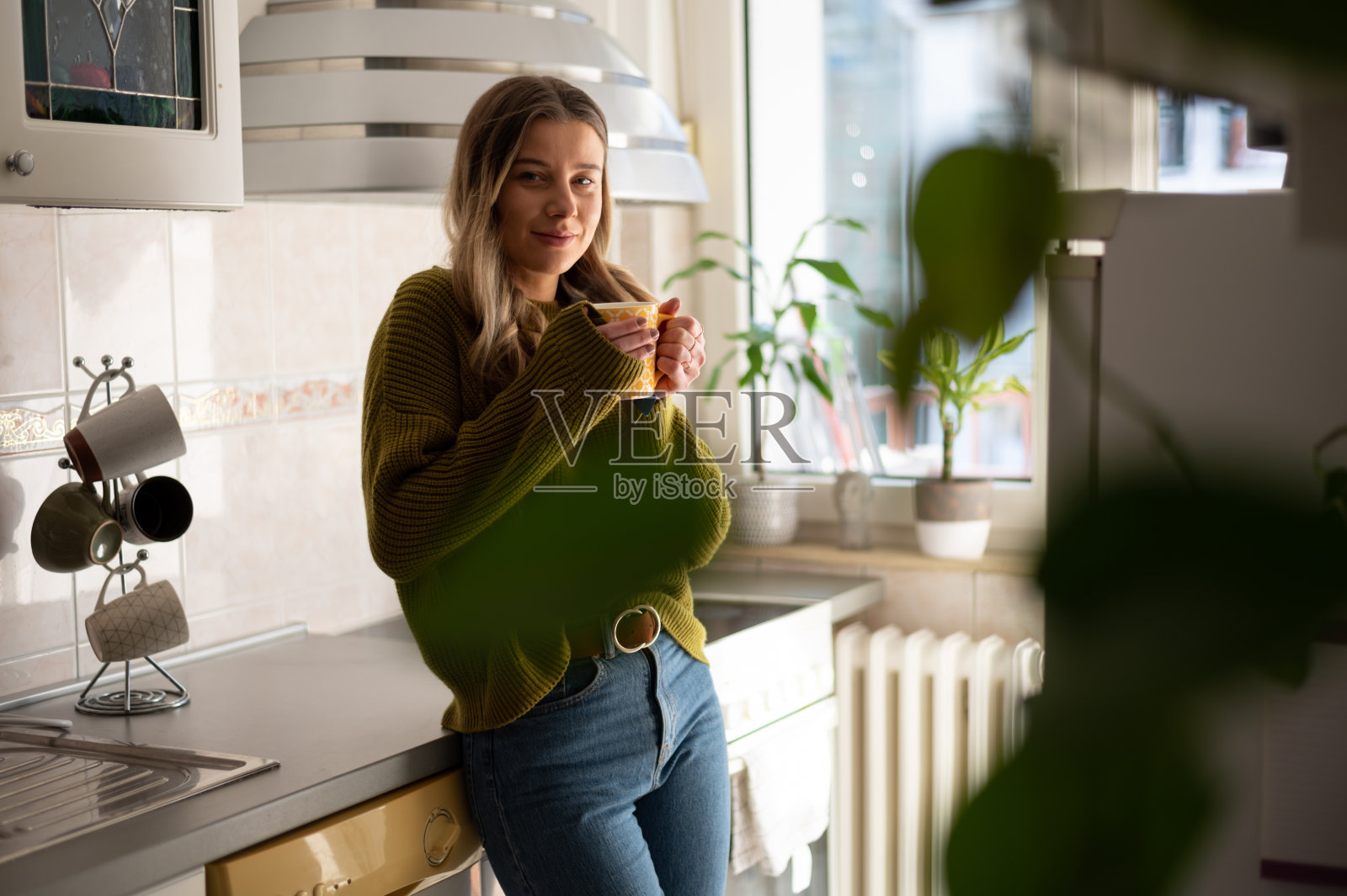 站在厨房里喝茶的女人照片摄影图片